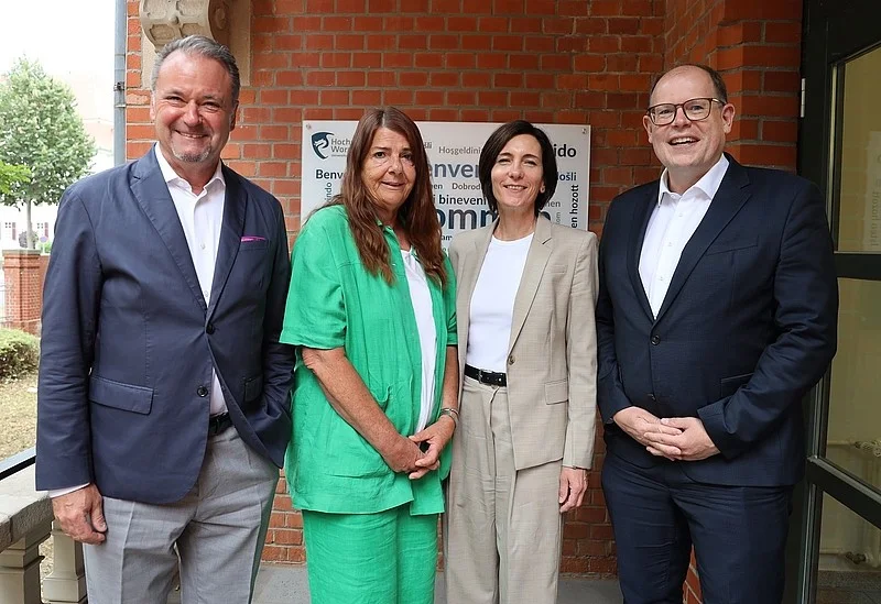 Gruppenfoto des Präsidiums der Hochschule Worms vor dem L-Gebäude; vier Personen stehen zusammen