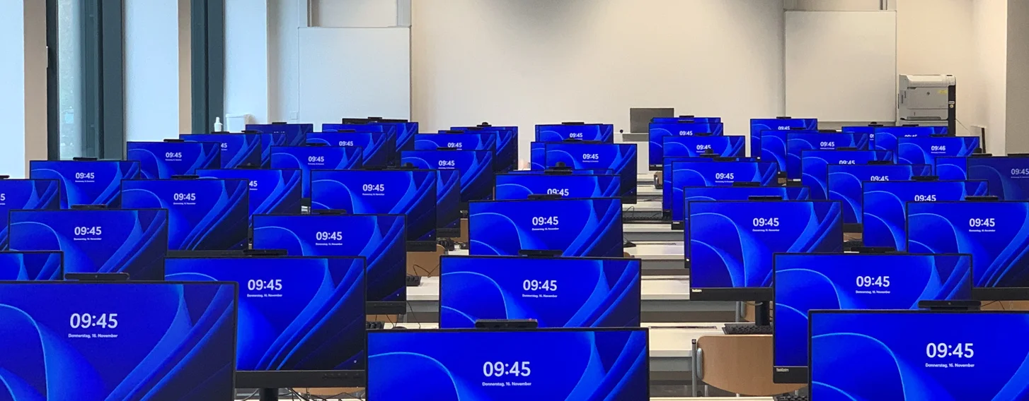 Vorbereiteter PC-Pool für eine Veranstaltung. Alle PCs sind eingeschaltet und zeigen den Windows Sperr-Bildschirm an.