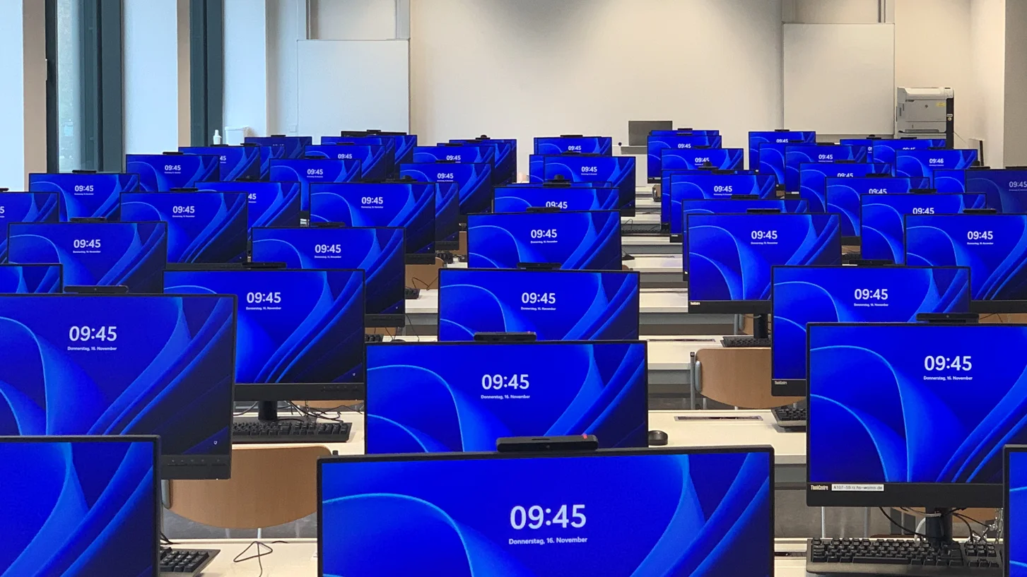 Vorbereiteter PC-Pool für eine Veranstaltung. Alle PCs sind eingeschaltet und zeigen den Windows Sperr-Bildschirm an.