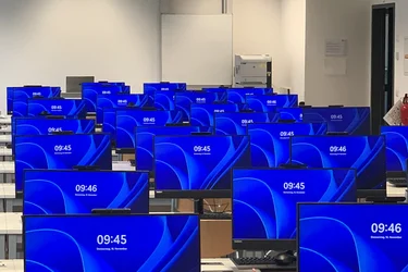 Vorbereiteter PC-Pool für eine Veranstaltung. Alle PCs sind eingeschaltet und zeigen den Windows Sperr-Bildschirm an.