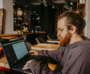 Ein Foto von einem Programmierer der Informatik, der an einem Laptop arbeitet.