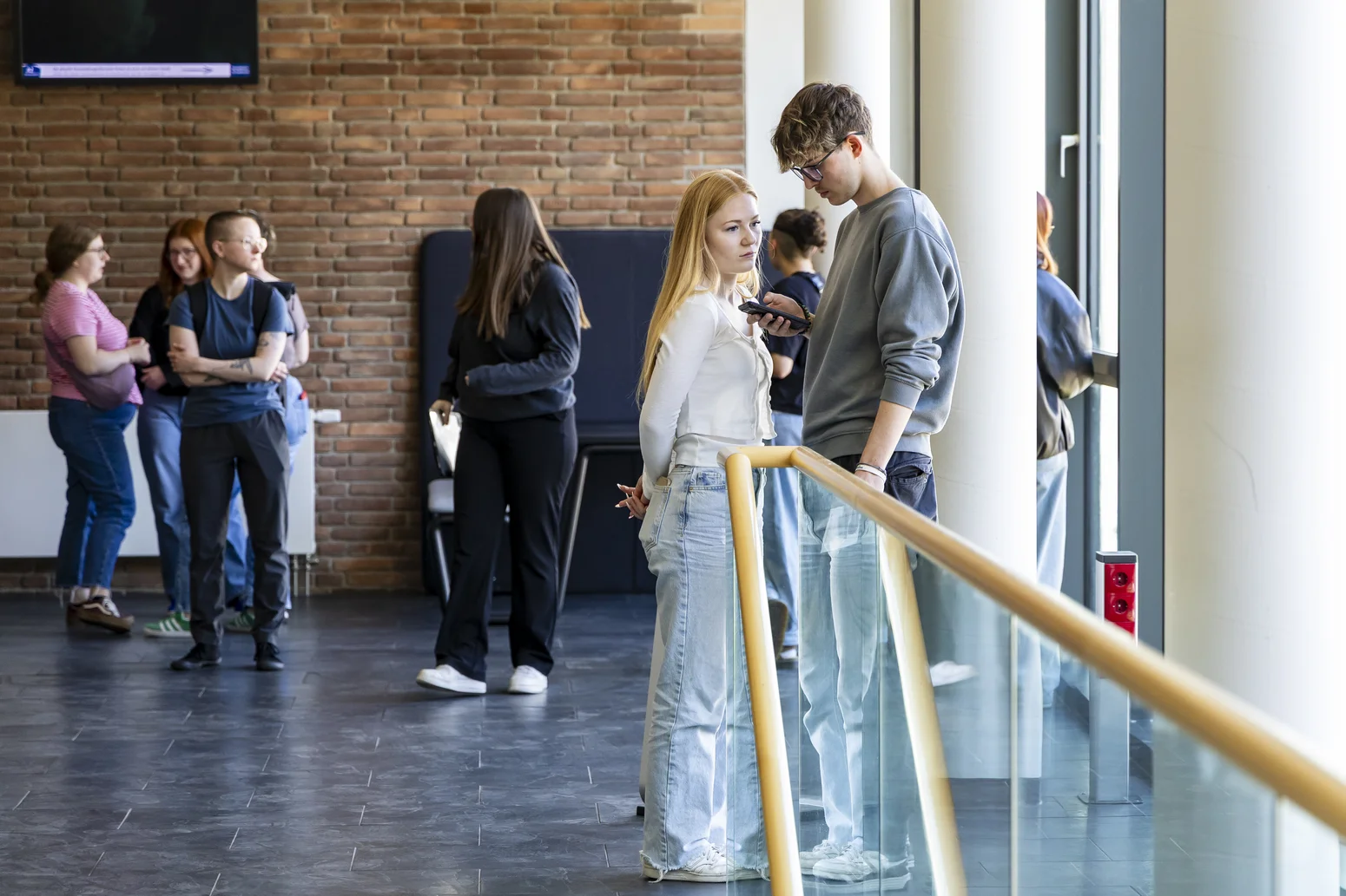 Studierende, die im Foyer stehen und sich unterhalten.